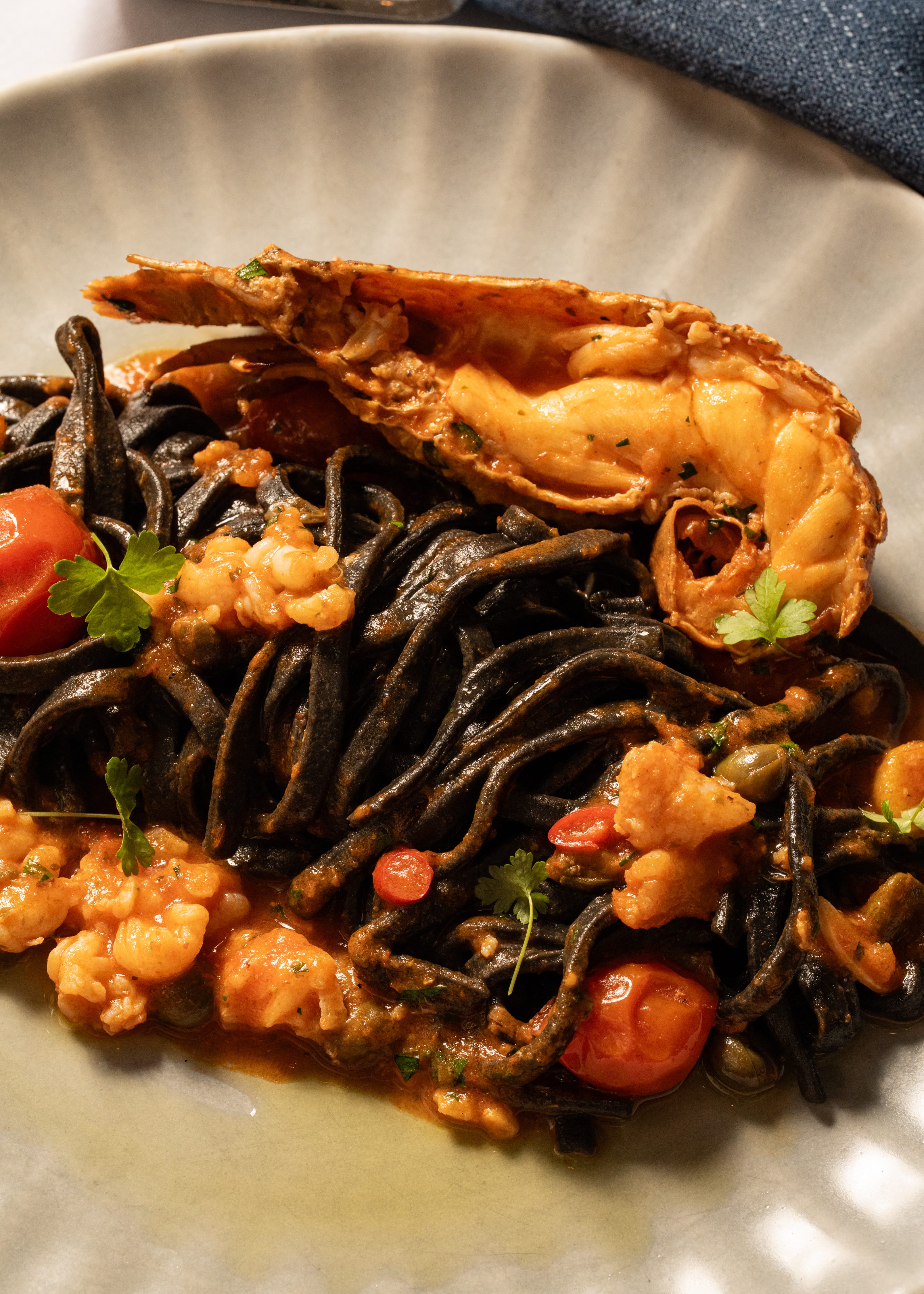 Black squid Tagliolini with Moreton bay bugs, chilli, garlic, cherry tomato, parsley